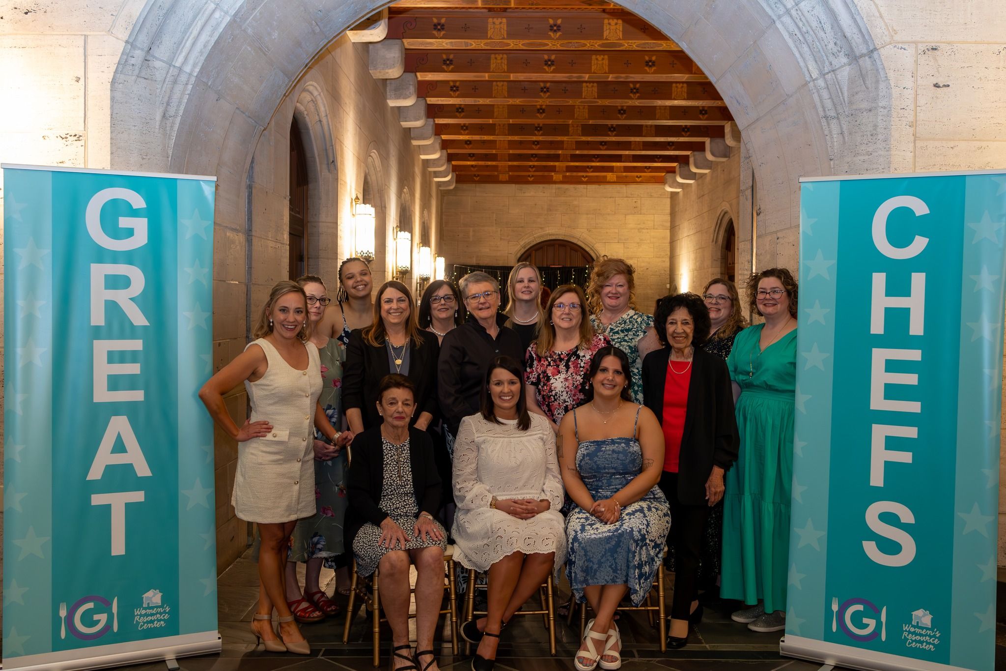 Group photo of the WRC members at the Great Chefs event between 2 signs that say CHEFS